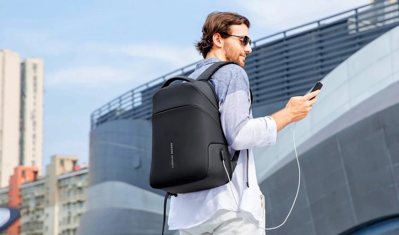 Người dùng đeo balo laptop màu đen đi trong thành phố